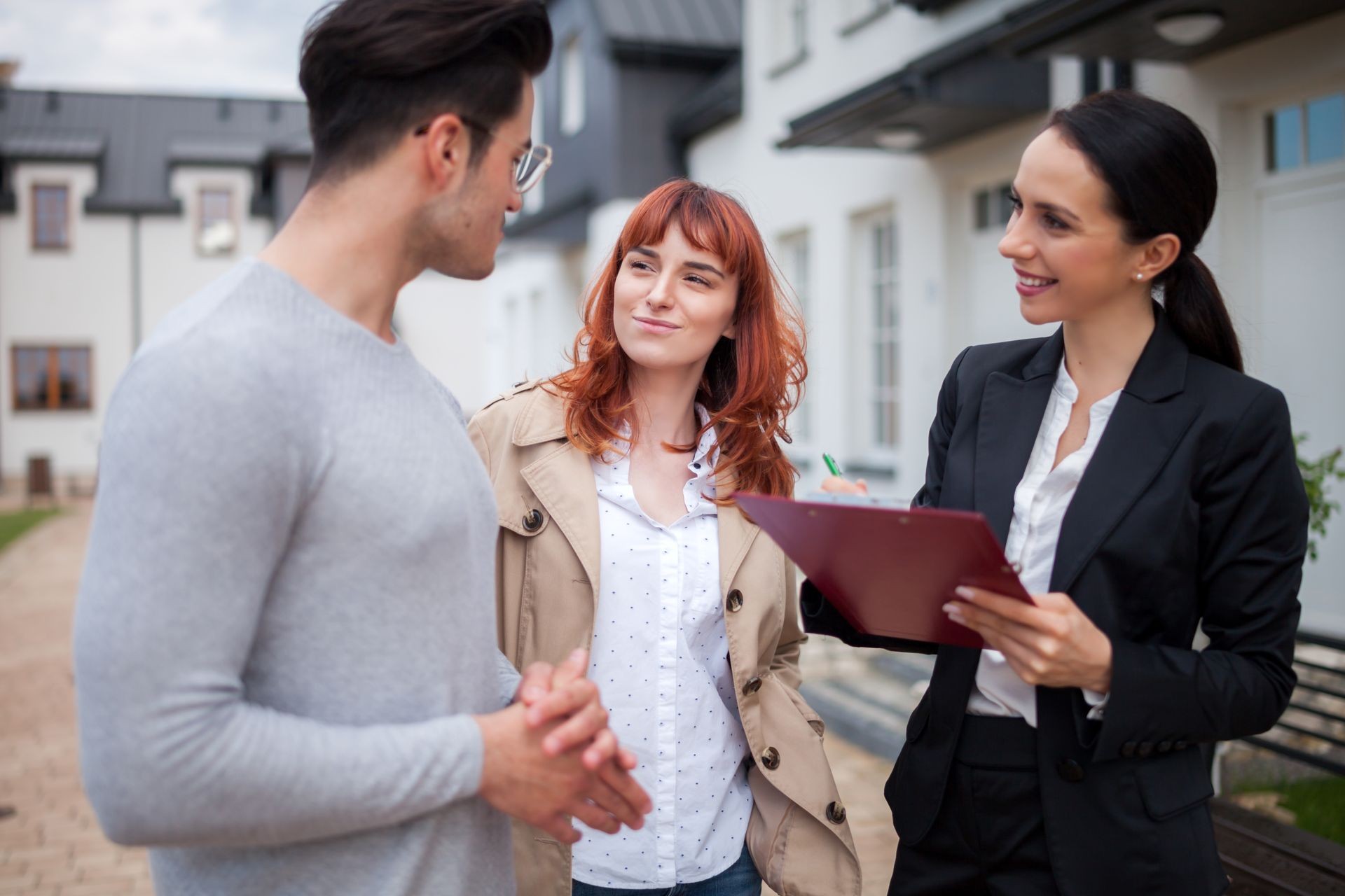 Real estate agent consulting young couple about buying new home